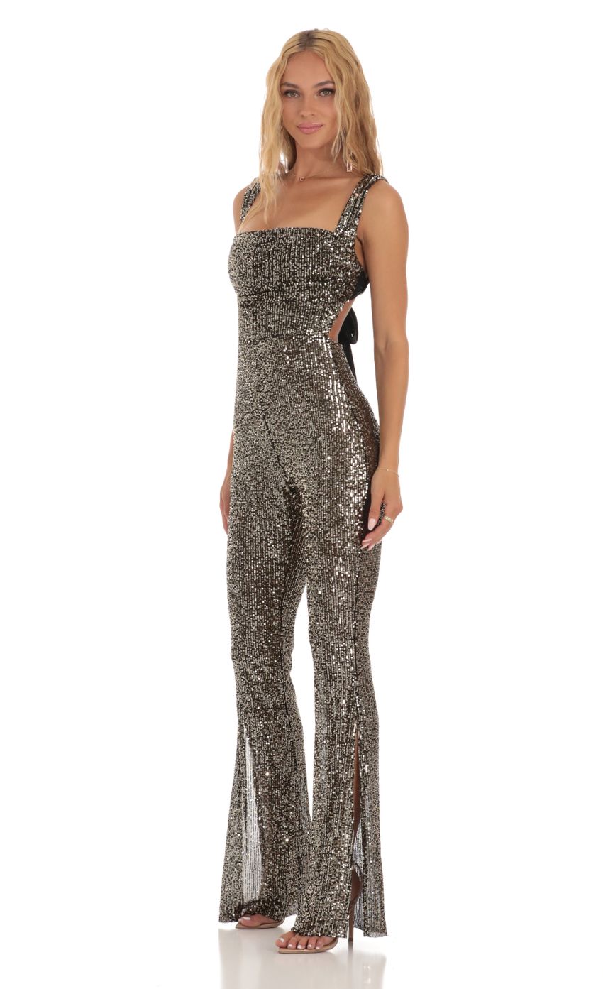 Picture Lupita Gold Sequin Back Bow Tie Jumpsuit in Black. Source: https://media.lucyinthesky.com/data/Jul23/850xAUTO/f52beb0c-b712-4f81-8bd1-631079b20440.jpg